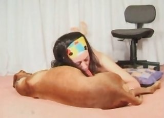 Brunette wears a mask and gives a blowage to a brown doggo